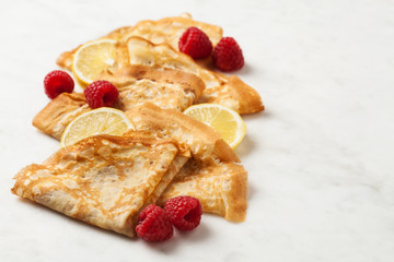 Folded pancakes on white marble background