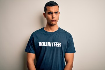 Young handsome african american man volunteering wearing t-shirt with volunteer message skeptic and nervous, frowning upset because of problem. Negative person.
