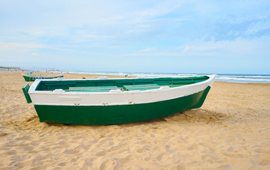 Naklejka premium Green boat in the sand on the beach