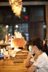 Portrait young woman with mask at coffee shop