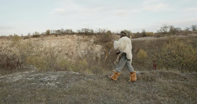 Hunter walking on cliff in nature