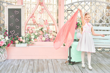 pretty little girl waves her hand. the child meets visitors on the platform. the concept