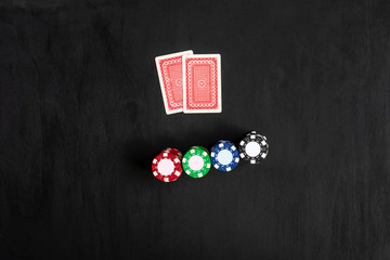 Two cards aces and chips, poker game. Black background, top view.