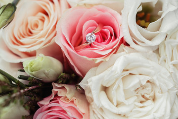 Perfect image with copy space for chic boho wedding magazines and websites, bohemian, fashion, florist. Flowers bouquet with nude roses and wedding rings. Copy space. Flowers background.