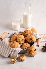 Chocolate chip cookies with milk bottles on white background