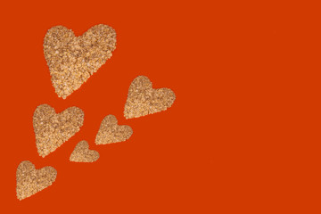 Six oatmeal hearts on an orange background. Romantic template. There are many hearts on the left