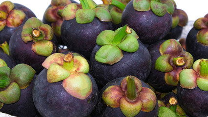 group of organic mangosteen fruit violet and green color. Sweet dessert in summer season in thailand. multivitamin juicy freshness vegetarian.