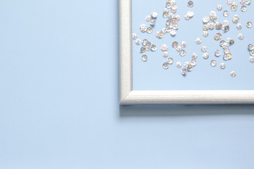 Corner of the silver frame is decorated with confetti with space for text on blue background.