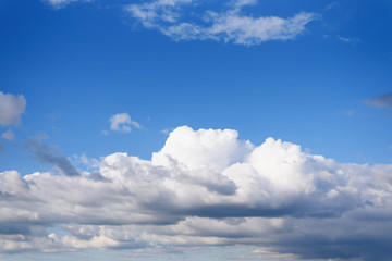 Blue bright sky with many sunny clouds.