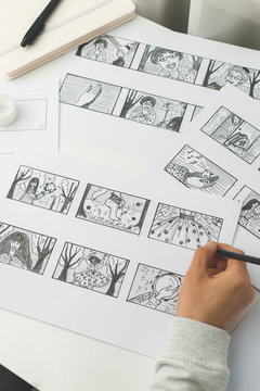 The hands of an illustrator painter draw a storyboard for a movie or cartoon.