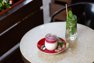 Vanilla Panna Cotta with Jelly of berries in glass jar. Italian dessert panna cotta. Classic Italian dessert creamy panna cotta with cherry sauce. Concept of pastry salon. Mojito and dessert.