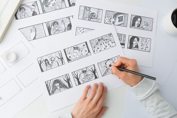The hands of an illustrator painter draw a storyboard for a movie or cartoon. - 352645583