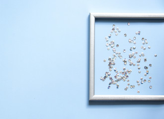 Part of the silver frame is decorated with confetti with space for text on blue background.