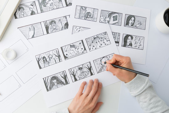The hands of an illustrator painter draw a storyboard for a movie or cartoon.