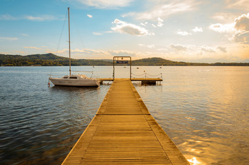 Lake pier with boat at sunset