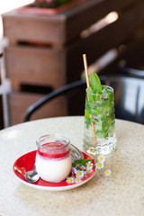 Vanilla Panna Cotta with Jelly of berries in glass jar. Italian dessert panna cotta. Classic Italian dessert creamy panna cotta with cherry sauce. Concept of pastry salon. Mojito and dessert.