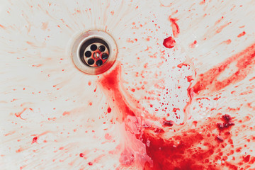 Fresh red blood splat on white porcelain with specks from the impact. Copy space area for horror...