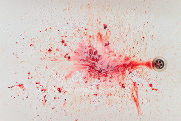 Fresh red blood splat on white porcelain with specks from the impact. Copy space area for horror...