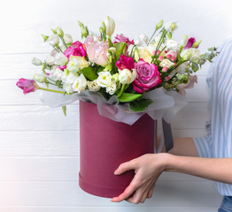 Girl is holding beautiful bouquet of flowers on white background. Roses, eustoma and tulips. Stylish present for all holidays. Happy birthday gift. Mother's day postcard. Spring mood. Women's day.