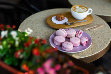 Obraz na płótnie Canvas Macaroons on a plate on a gray background. French macarons isolated. Selective focus. Beautiful pink macaroons with coffee. Stylish arrangement sweet. Flat lay, top view. Macro photo.