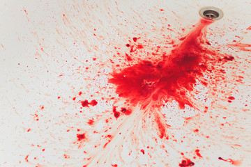 Fresh red blood splat on white porcelain with specks from the impact. Copy space area for horror...