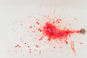 Fresh red blood splat on white porcelain with specks from the impact. Copy space area for horror...