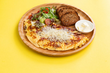 breakfast. omelet, salad and toasts in a wooden plate.