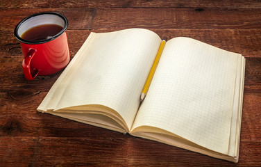 old blank notebook and tea on a rustic table