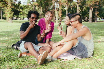 Fototapeta premium A group of friends having ice cream together in a park
