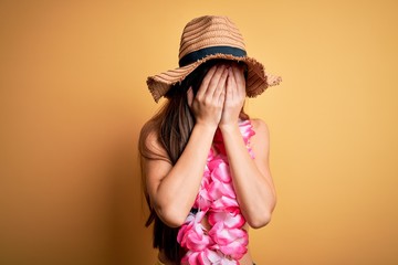 Young beautiful woman with blue eyes on vacation wearing bikini and hawaiian lei with sad...