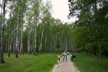 Happy loving mother and two children, son and daughter hiking in forest. Family walk in nature park. Summer camping.. Summer time camping.