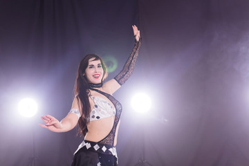 Girl dancing belly dance, fusion or tribal. A woman in a beautiful costume demonstrates charming and gentle movements in the dance. Copy space.