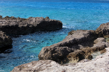 rocks against a bright blue ocean scene