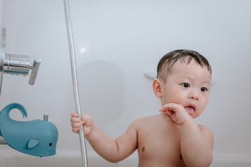 Little baby boy, playing in bathtub