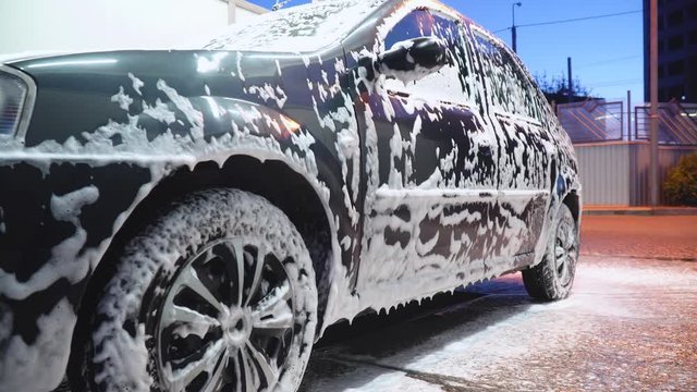 Close up clean car concept at car wash. Washing car with soap. Car wash