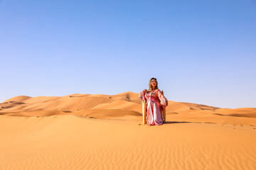 Fototapeta na wymiar A girl in a beautiful Moroccan dress. Merzouga Morocco.
