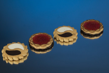 Cake with jam on a blue mirror background