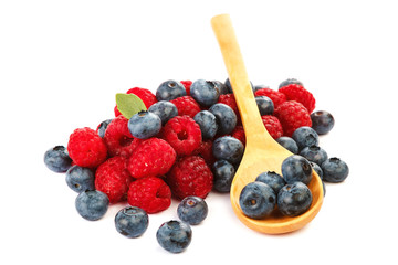 Fresh blueberries and raspberries with a wooden spoon