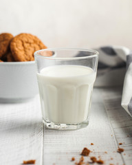  Glass of milk close-up, cookies in a bowl on a wooden background. The concept of milk, dairy products, farm products.