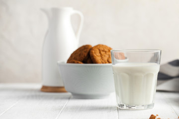  Glass of milk, milk jug, cookies in a bowl on a light background. concept of dairy products, farm products. Copy space.