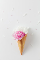 Bouquet of white and pink peonies in a waffle cone