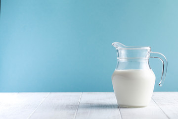  Jug of milk on a blue background. The concept of farm dairy products, the use of milk, milk day. Copy space.