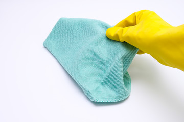 Hand in yellow rubber glove holding microfiber cloth in order to wipe, wash the dust, cleaning up the house concept, white background