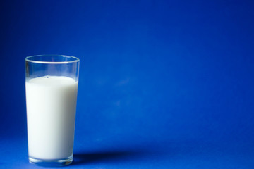 World milk day. Glass of milk on blue background. Copy space. 