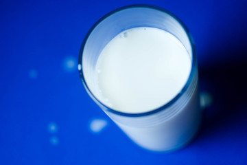 Top view glass of mils with drops on table. Copy space. International milk day. Calcium products 