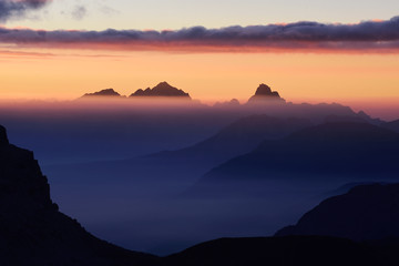 Fototapeta na wymiar High peaks of mountains shrouded in morning mist.