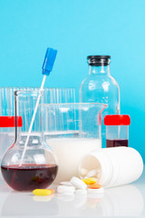 Glassware with red and white liquids, test-tube and flask for laboratory analysis. Laboratory medical research, chemical lab.