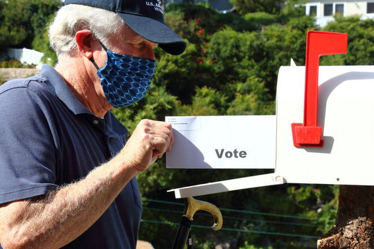 Elderly man voting by mail