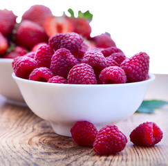 Bowls overflowing with summer berries like raspberries and blackberries.