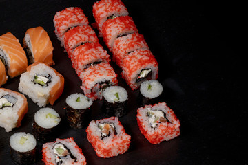 Set of sushi roll on black slate background food fish philadelphia japanese salmon delicious sushi rice cucumber meal traditional wasabi fresh healthy gourmet raw cuisine